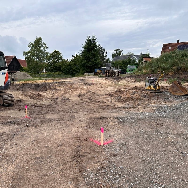 Abgesteckte Gebäudeecken mit Pflöcken auf einem Baugrundstück