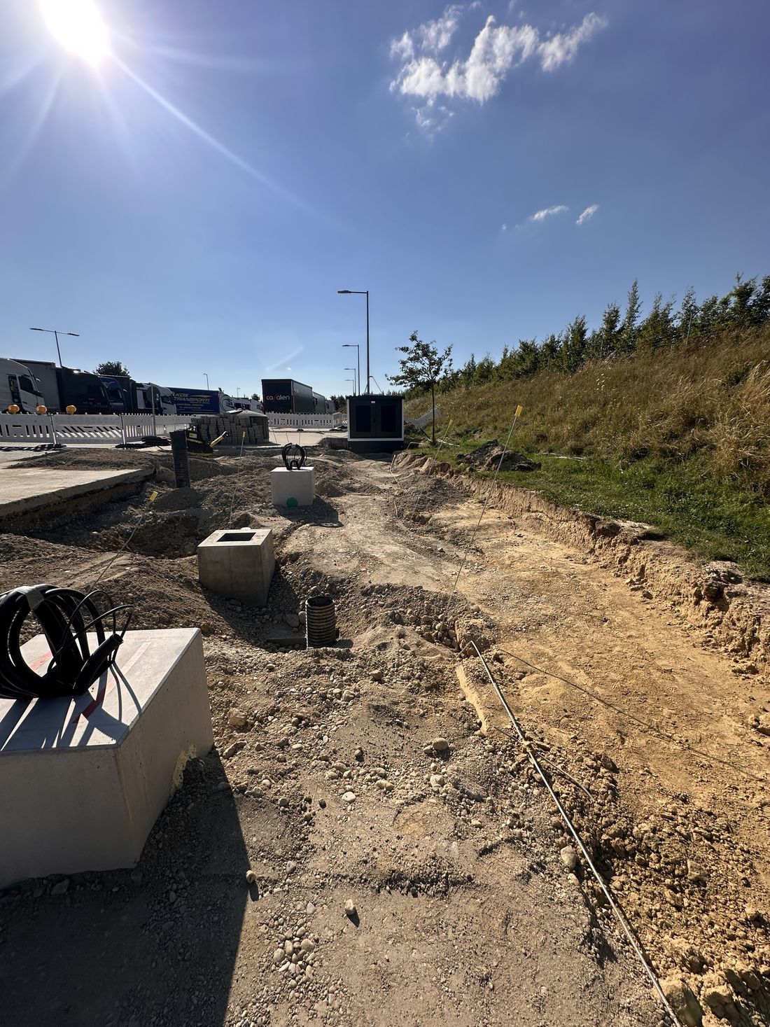 Baustelle eines Schnellladeparks mit Fundamenten und verlegten Leitungen
